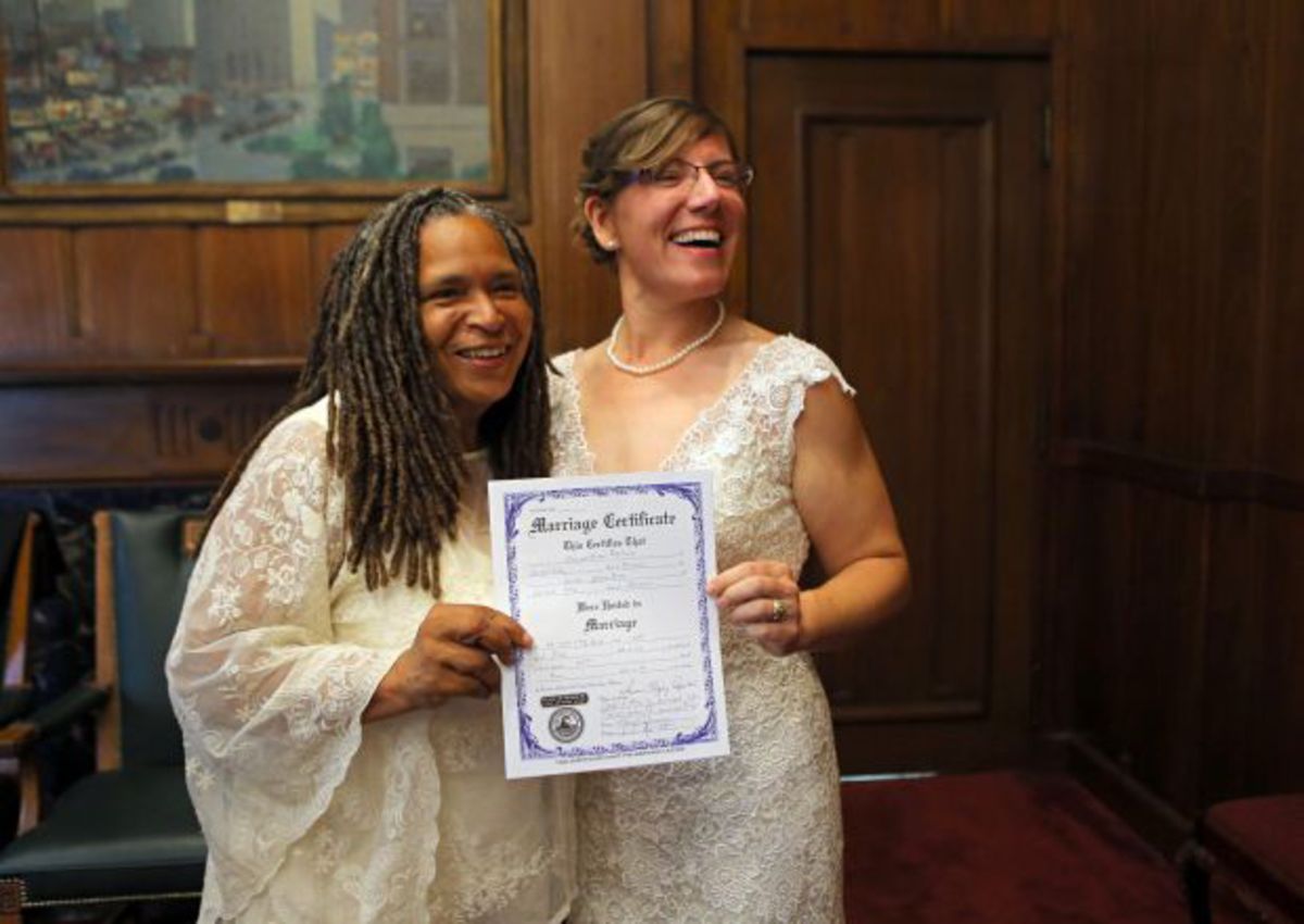 Mimo Davis and Miranda Duschack show off their		 David Gray and Tod Martin.signed marriage certification in St. Louis City Hall on Wednesday, June 25, 2014