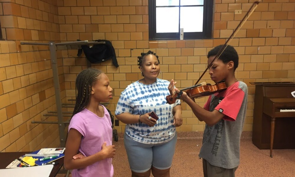 Boy with instructor learning to play violin