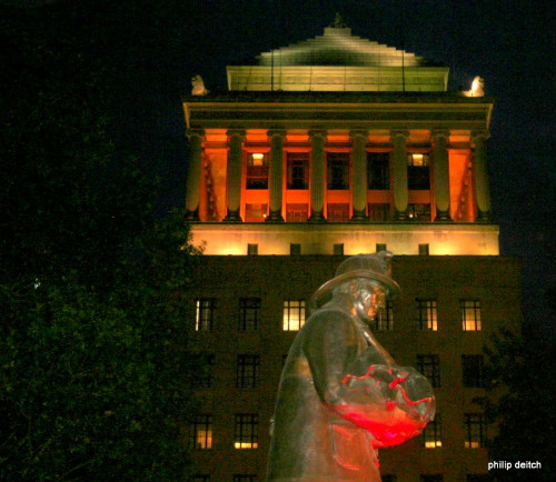 The illuminated Firefighter Statue and Civil Courts Building serve as a backdrop for the ceremony.