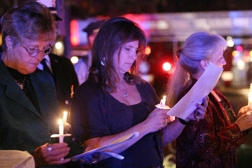 Laura Morrison looks at the program during the reading of nearly 200 names of St. Louis area firefighters that have died in the line of duty.