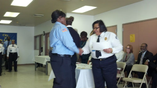 Major Irene Mitchell awards a certificate to a new officer.