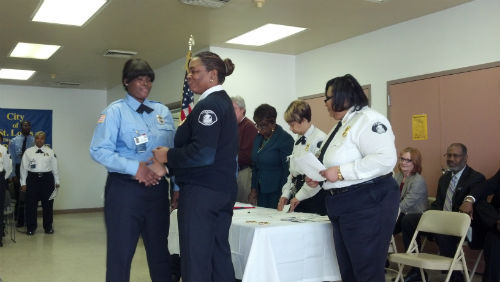 Major Tonya Harry congratulates new officer after receiving her badge.