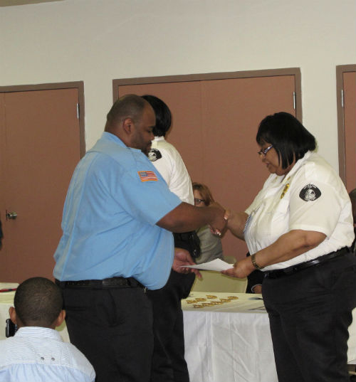 One of our new officers receives his certificate from Major Irene Mitchell