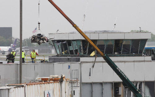 Workers remove debris the day after the destructive tornado that hit Lambert Airport.