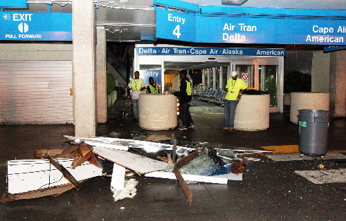 Workers survey damage to the arrival area at Lambert Airport on April 22, 2011.