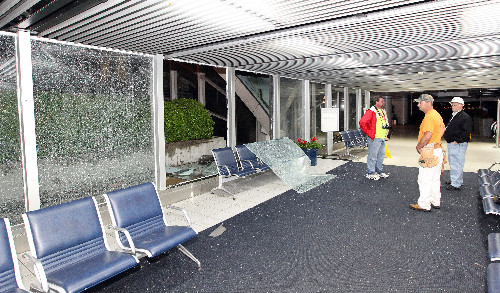 Workers survey damage to windows at Lambert Airport, April 22, 2011.